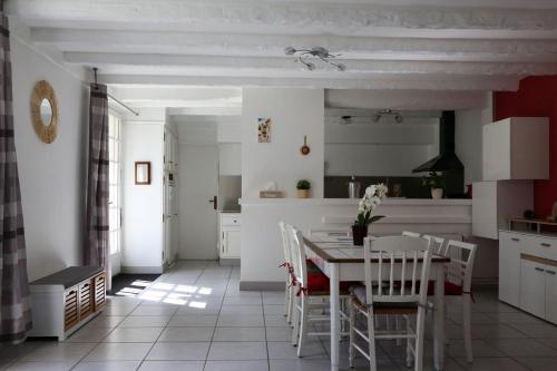 une cuisine et une salle à manger avec une table et des chaises dans l'établissement Le relais d'Eugénie Maison d'hôtes en forêt d'Orléans, à Courcy-aux-Loges