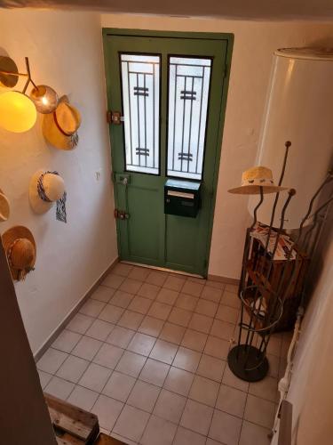 a green door in a room with a tile floor at Lumineux Duplex au coeur de l'Isle in LʼIsle-sur-la-Sorgue