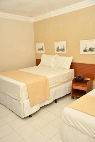 a hotel room with two beds and a table at Troodon Park Hotel in Sousa