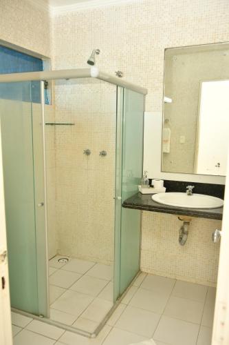 a bathroom with a glass shower and a sink at Troodon Park Hotel in Sousa