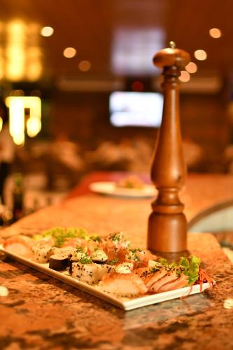 a pizza on a plate on a table at Troodon Park Hotel in Sousa