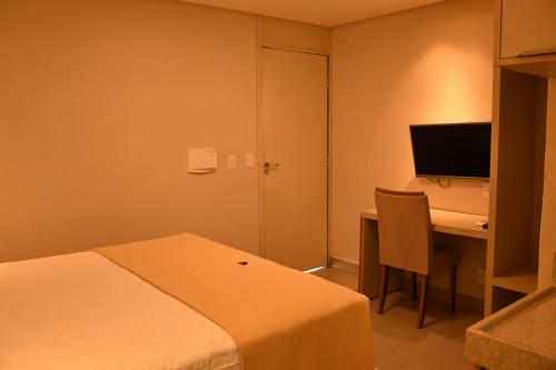 a hotel room with a bed and a desk with a computer at Troodon Park Hotel in Sousa