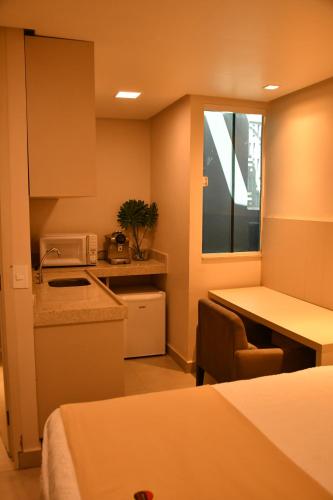 a room with a kitchen and a table with a microwave at Troodon Park Hotel in Sousa