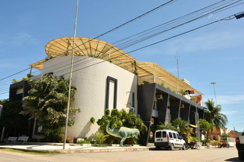 a building with a dinosaur statue in front of it at Troodon Park Hotel in Sousa
