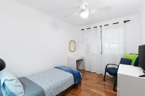 a bedroom with a bed and a desk and a television at Close to lake, golf & beach, perfect for long stay in Toukley