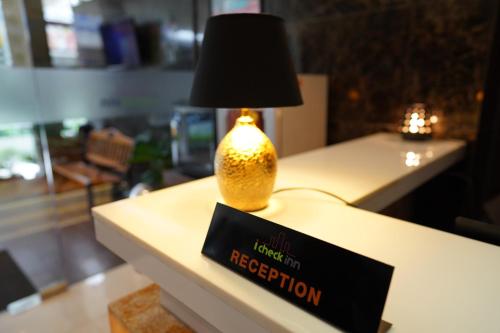 a lamp sitting on a table with a sign on it at iCheck inn Nana by Aspira in Bangkok