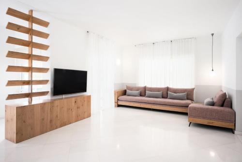 - un salon avec deux canapés et une télévision dans l'établissement Villa Giota, à La Canée