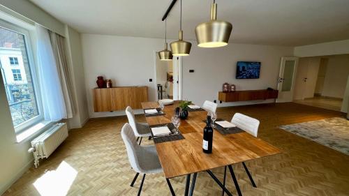 jadalnia z drewnianym stołem i krzesłami w obiekcie Aalst City Center Apartment w mieście Aalst