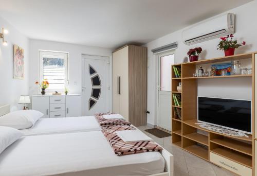 a bedroom with two beds and a flat screen tv at Lorena Apartment Dubrovnik in Dubrovnik