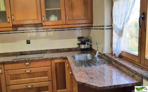 a kitchen counter with a sink and a window at Casa Vacacional Mari Paz in Llanes