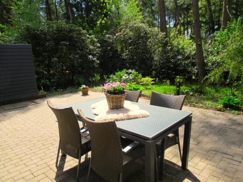 a table with chairs and a basket of flowers on it at Secret Wellness Puur Natuur in Holten