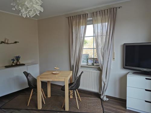 a dining room with a table and chairs and a window at Entspannt Wohnen - vor den Toren Lübecks in Stockelsdorf