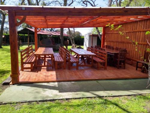 a wooden pergola with tables and chairs on a deck at La Posada del Indio in Mar del Plata