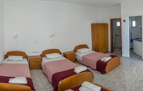 a hotel room with three beds and a bathroom at Villa Chrissa in Limenaria