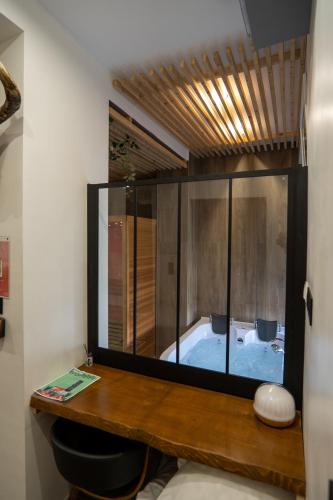 Cette chambre comprend une salle de bains pourvue d'une grande baignoire. dans l'établissement Capsule Wellness - sauna - balneo - machine de sport privatif - PS5 - 2 chambres, à Valenciennes