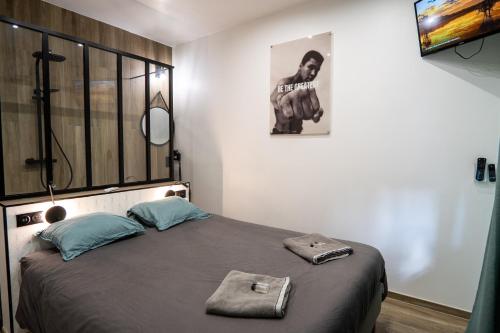a bedroom with a large bed with a large window at Capsule Wellness - sauna - balneo - machine de sport privatif - PS5 - 2 chambres in Valenciennes