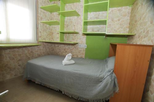 a small room with a bed with green shelves at COSTA DAURADA APARTAMENTS - Cye 7 in Salou