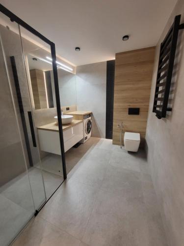 ein Bad mit einem Waschbecken und einem WC in der Unterkunft Apartament na Chopina 5 in Kołobrzeg