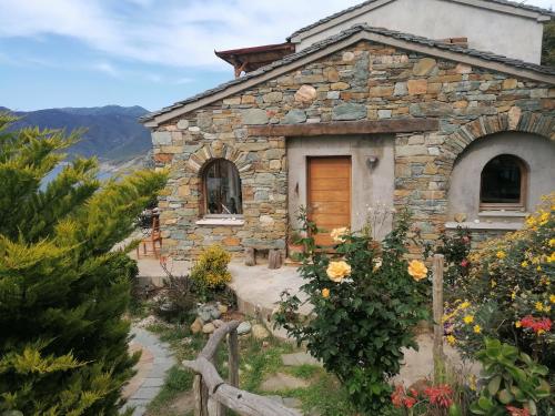 a stone house with a wooden door in a garden at Logement de charme avec piscine privative in Pino