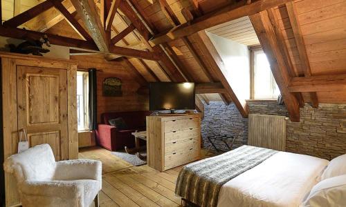 een slaapkamer met een bed en een tv in een kamer bij Le Moulin de Lily in Palaiseau