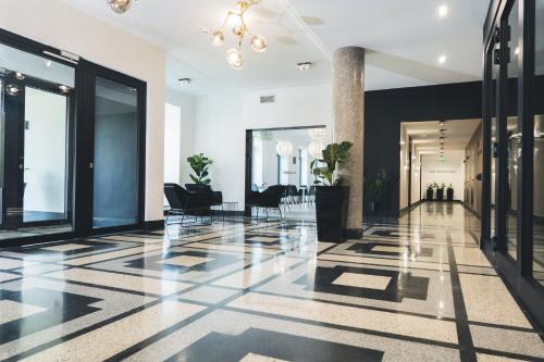 a lobby with black and white floors and a chandelier at VANTA Business Center in Skawina