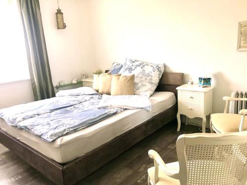 ein Bett mit blauer Bettwäsche und Kissen in einem Schlafzimmer in der Unterkunft Ferien-Sempachersee Sandra Sens in Sempach