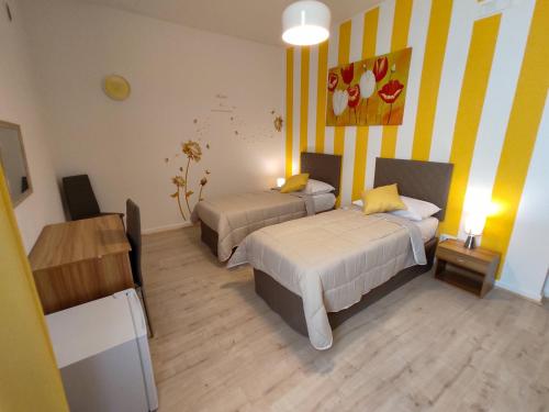 a room with two beds and a painting on the wall at Cerva Bianca B&B in Santa Maria Capua Vetere