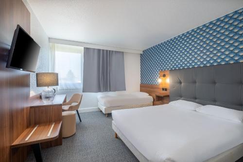 a hotel room with a bedroom with a bed and a desk at Hôtel Akena Poitiers Nord Futuroscope in Chasseneuil-du-Poitou