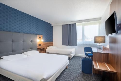 a hotel room with a bed and a desk at Hôtel Akena Poitiers Nord Futuroscope in Chasseneuil-du-Poitou