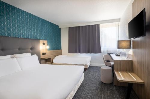 a hotel room with two beds and a desk at Hôtel Akena Poitiers Nord Futuroscope in Chasseneuil-du-Poitou