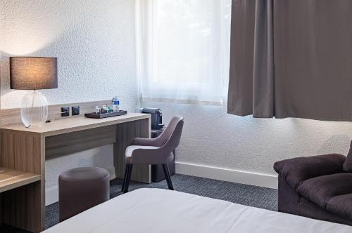 a hotel room with a desk and a bed at Hôtel Akena Poitiers Nord Futuroscope in Chasseneuil-du-Poitou