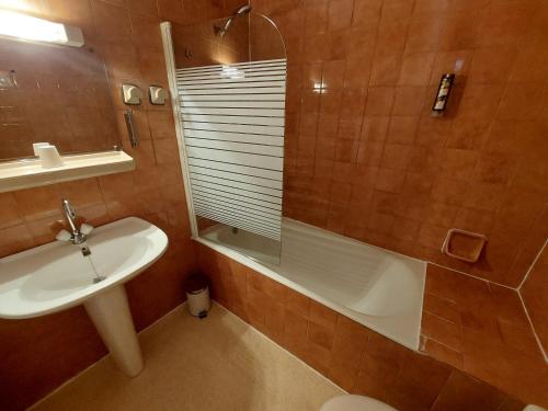 a bathroom with a sink and a tub and a toilet at Logis Hotels - La Table d'Antan - Hôtel 2 étoiles et Restaurant in Bon-Encontre