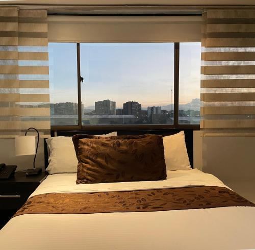Schlafzimmer mit einem Bett und einem großen Fenster in der Unterkunft Hotel Airport Travel in Bogotá