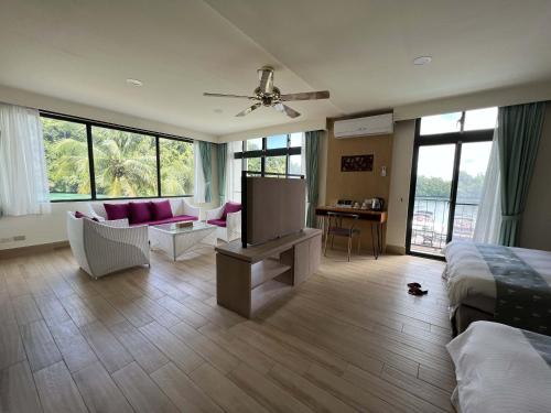 a bedroom with a bed and a living room with a tv at Sea Passion Hotel in Koror