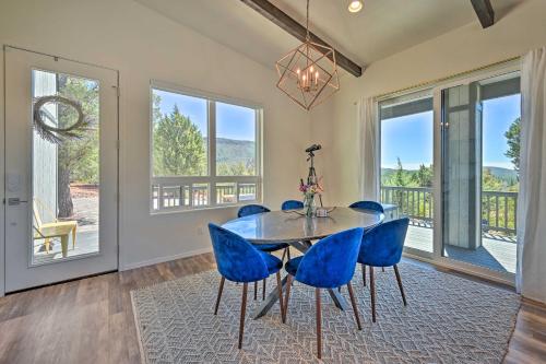 a dining room with a table and blue chairs at Mtn Views and Gas Fire Pit Luxe Pine Escape! in Pine