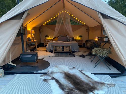 namiot z łóżkiem w środku w obiekcie Glamping Tent with amazing view in the forest w mieście Torsby
