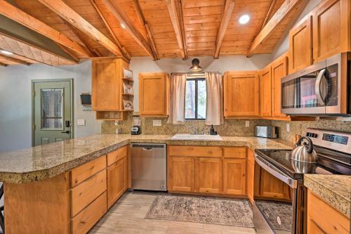 a kitchen with wooden cabinets and a sink at Cabin in Tonto National Forest Deck and Views! in Pine
