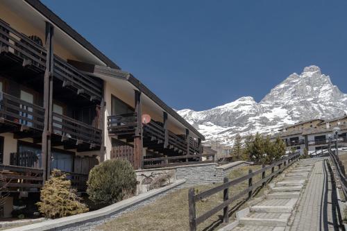eine Ski-Lodge mit einem Berg im Hintergrund in der Unterkunft HelloChalet - Ski paradise Apartment - Ski- to door with big terrace overlooking skiruns in Breuil-Cervinia