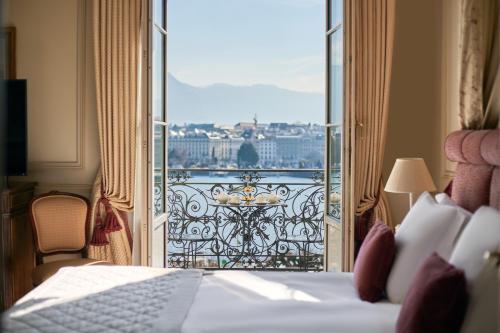 a hotel room with a bed and a view of a balcony at Beau-Rivage Genève in Geneva