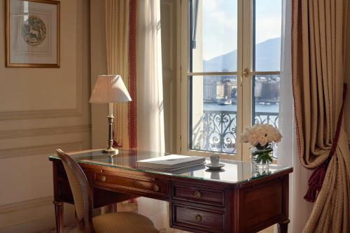 a desk with a window and a desk with a lamp at Beau-Rivage Genève in Geneva