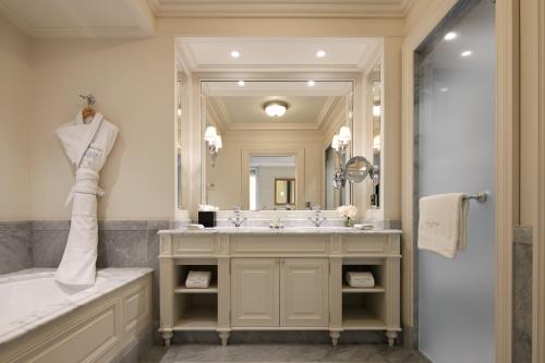 a bathroom with a tub and a sink and a mirror at Beau-Rivage Genève in Geneva