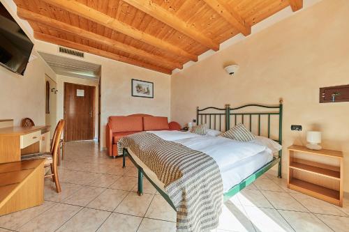 - une chambre avec un lit, un bureau et une télévision dans l'établissement Hotel Rosemarie, à Limone sul Garda
