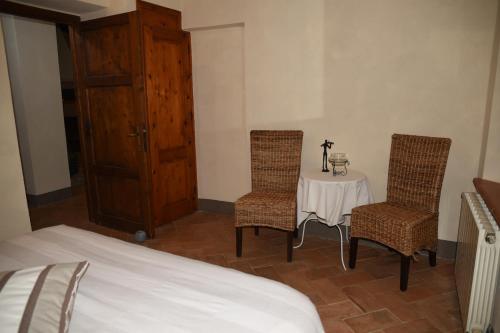 a bedroom with a table and two chairs and a bed at Agriturismo Poggio ai Legni in Sovicille