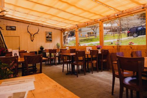 a restaurant with wooden tables and chairs and windows at Bubble-Suite mit wunderschönem Blick in Lumbrein