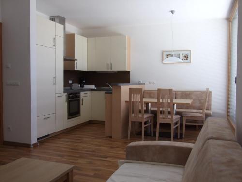 Una cocina y una sala de estar con mesa y sillas. en Tauberhof Apartments, en Bresanona