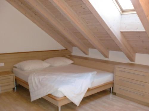 Un dormitorio con una cama en un ático en Tauberhof Apartments, en Bresanona