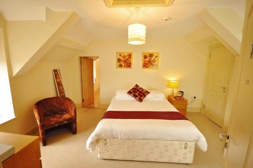 1 dormitorio con 1 cama y 1 silla en The Castle Hotel en Talgarth