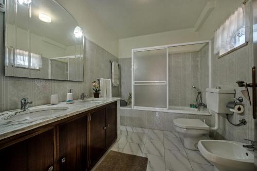 a bathroom with two sinks and a toilet and a mirror at 5BR Villa with Private Pool and Snooker Room in Carvoeiro