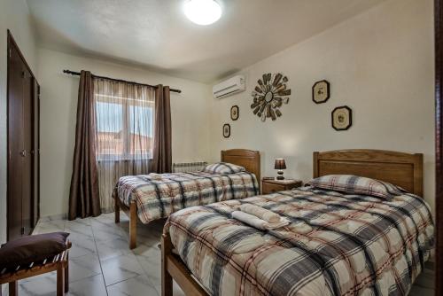 a bedroom with two beds and a window at 5BR Villa with Private Pool and Snooker Room in Carvoeiro