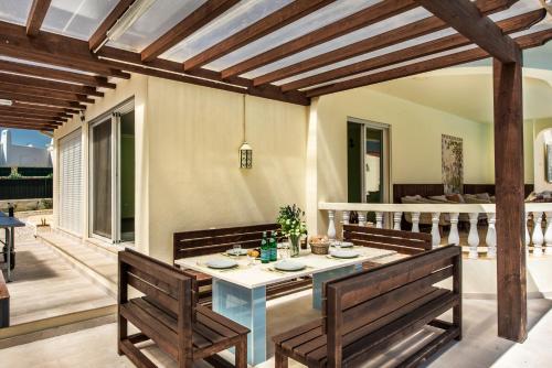a patio with a table and two benches at 5BR Villa with Private Pool and Snooker Room in Carvoeiro